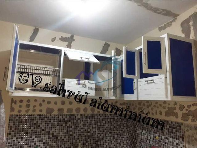 Pemasangan kabinet gantung atas kitchen set aluminium putih biru oleh CV. Sahrul Aluminium