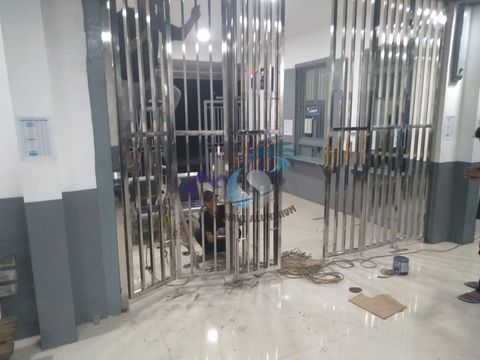 Pemasangan pintu folding gate stainless steel untuk pengamanan bangunan oleh CV. Sahrul Aluminium
