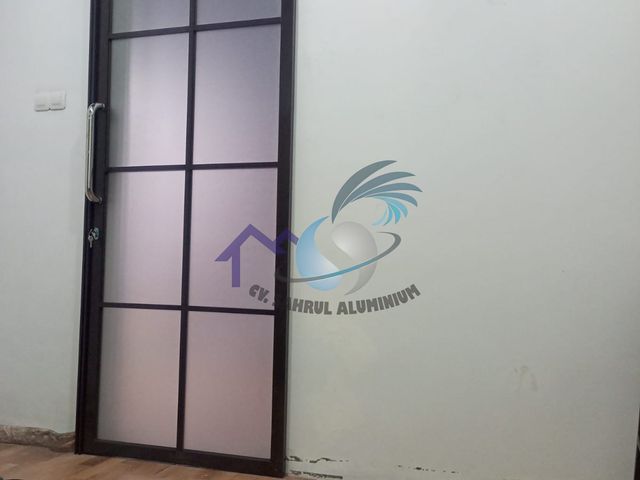 Pemasangan pintu geser gantung aluminium kaca hitam oleh CV. Sahrul Aluminium