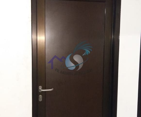 Pintu aluminium cokelat kombinasi panel dan kaca atas oleh CV. Sahrul Aluminium