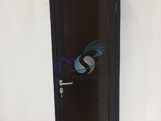 Pintu tunggal panel spandrel aluminium hitam buatan CV. Sahrul Aluminium