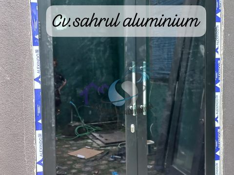 Pintu kaca ganda bingkai aluminium hitam dengan handle stainless hasil pemasangan tim