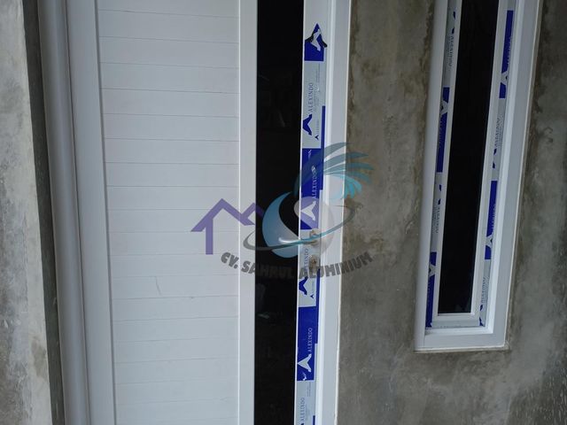 Pemasangan pintu utama ganda panel aluminium putih oleh CV. Sahrul Aluminium