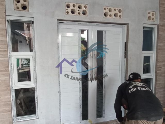 Pintu utama panel aluminium putih kombinasi kaca vertikal oleh CV. Sahrul Aluminium